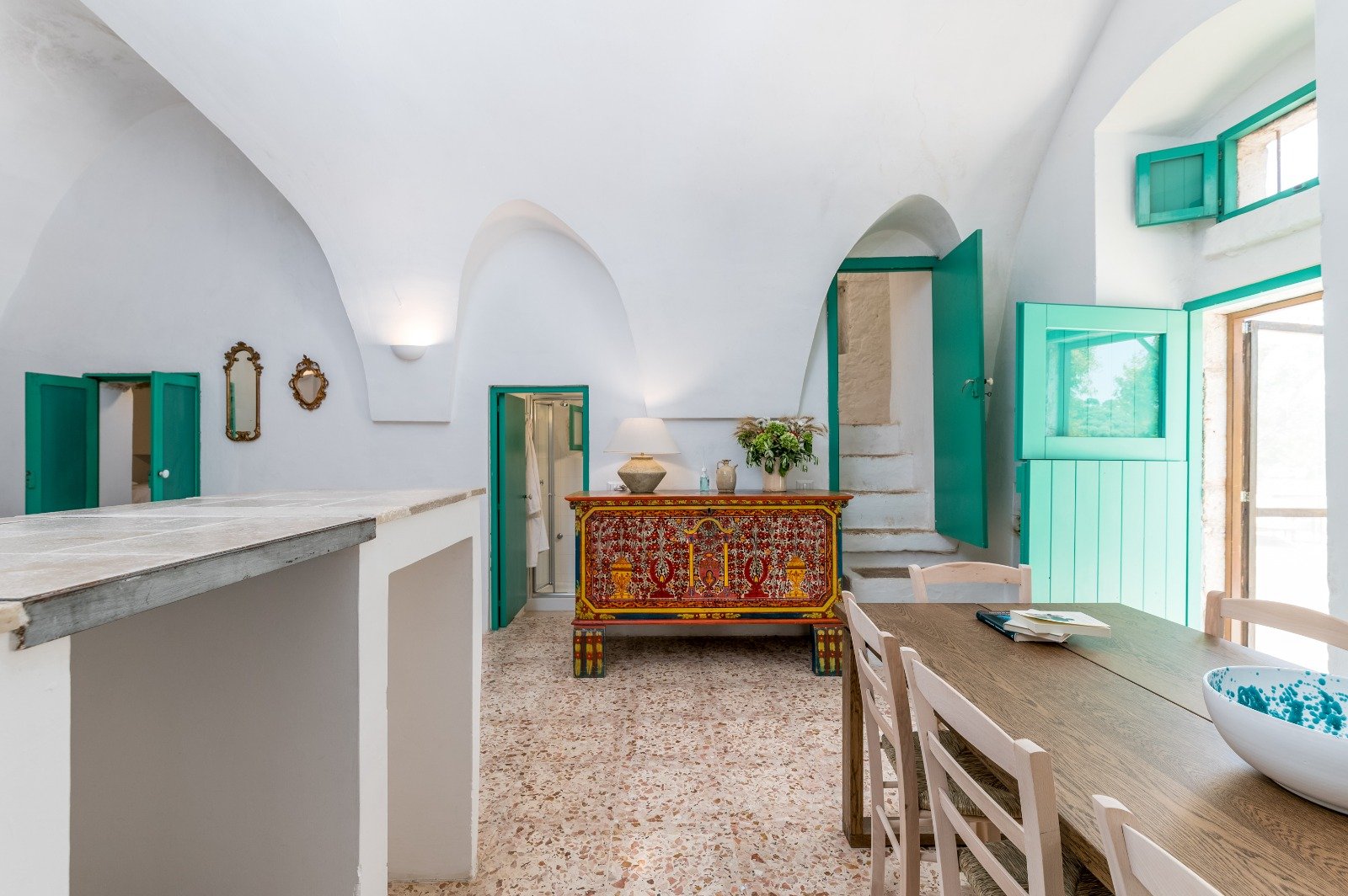 Cucina e zona giorno con infissi verdi della masseria a Ostuni